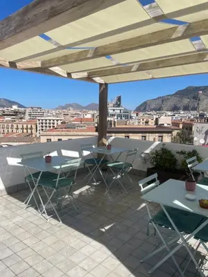 a patio with tables and chairs and a view of the city at La Terrazza su Palermo in Palermo
