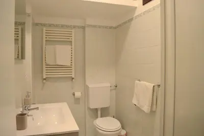 a white bathroom with a toilet and a sink at Casa Amari Bd in Palermo