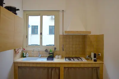 a kitchen with a sink and a stove and a window at Casa Amari Bd in Palermo