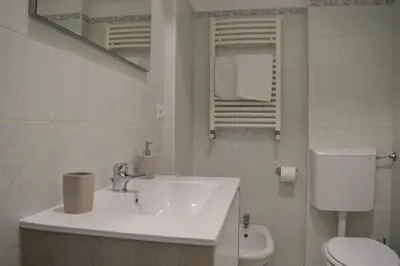 a white bathroom with a sink and a toilet at Casa Amari Bd in Palermo