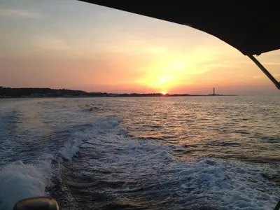 a boat in the water with the sunset in the background at Loft Sul Mare in Balestrate