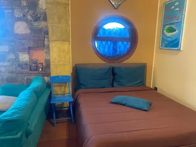 a living room with a couch and a window at Loft Sul Mare in Balestrate