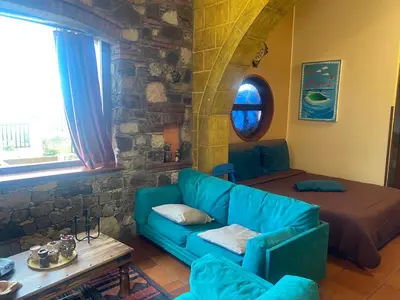 a living room with a blue couch and a bed at Loft Sul Mare in Balestrate