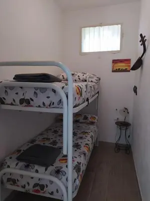 two bunk beds in a small room with a window at Rifugio Riserva Grotta Mazzamuto in Altavilla Milicia