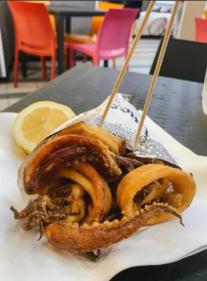 a plate of food with onion rings and a lemon at Luna di Sicilia in Palermo