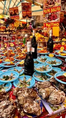 a table with plates of food and bottles of wine at Luna di Sicilia in Palermo