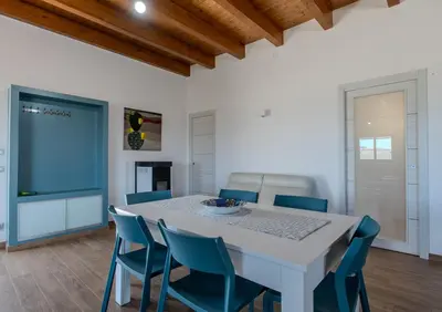 a dining room with a white table and blue chairs at Villa Ginevra in Santa Ninfa