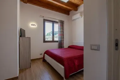 a bedroom with a red bed and a window at Villa Ginevra in Santa Ninfa