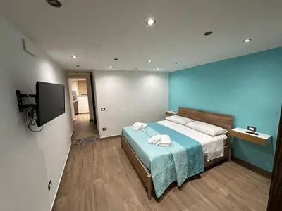 a bedroom with a bed and a flat screen tv at Lucky House in Palermo