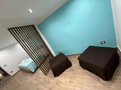 a bedroom with a bed and a couch in a room at Lucky House in Palermo