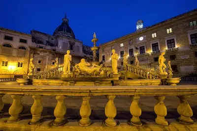 a large fountain in front of a building at night at Lucky House in Palermo
