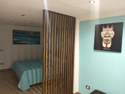 a room with a wooden partition with a bed and a picture at Lucky House in Palermo