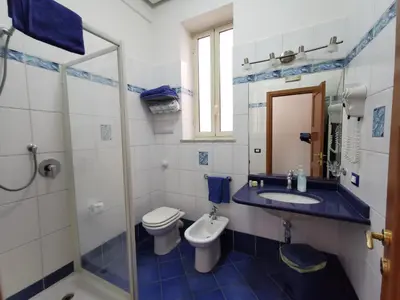 a blue and white bathroom with a toilet and a sink at Appartamento Tirreno Mondello in Palermo