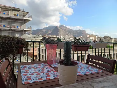 a table on a balcony with a view of a mountain at Al Duca appartamento in centro in Palermo
