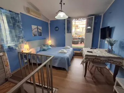 a bedroom with blue walls and a bed and a table at La Casa di Giovy in Palermo