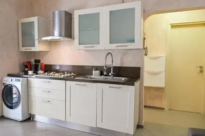 a kitchen with white cabinets and a sink and a dishwasher at Modern apartment center Palermo in Palermo