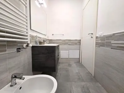 a white bathroom with a sink and a mirror at Maison Zisa - Proppro SRL - Palermo in Palermo