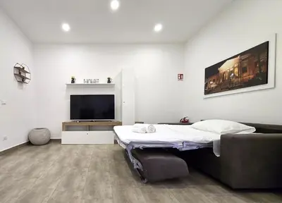 a living room with a bed and a television at Maison Zisa - Proppro SRL - Palermo in Palermo