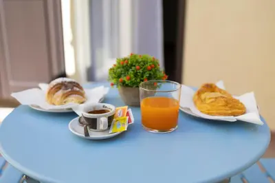 a table with a glass of orange juice and pastries at Maison Zisa - Proppro SRL - Palermo in Palermo