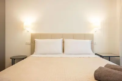 a bed with two white pillows and two tables at Luxury Villa Leto in Palermo