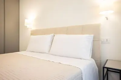 a white bed with white pillows in a room at Luxury Villa Leto in Palermo