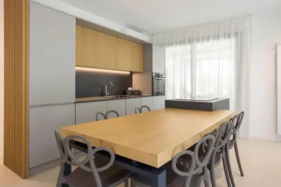 a kitchen with a wooden table and chairs at Luxury Villa Leto in Palermo