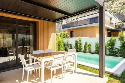 a patio with a table and chairs and a swimming pool at Luxury Villa Artemis Mondello in Palermo
