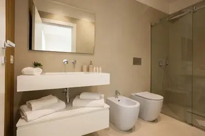 a bathroom with a sink and a toilet and a mirror at Luxury Villa Artemis Mondello in Palermo