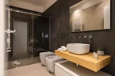 a bathroom with a sink and a toilet and a mirror at Luxury Villa Artemis Mondello in Palermo
