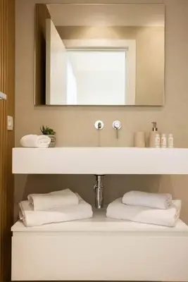 a bathroom with a sink with a mirror and towels at Luxury Villa Artemis Mondello in Palermo