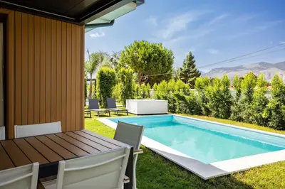 a backyard with a swimming pool and a table and chairs at Luxury Jacuzzi Villa Diana in Palermo