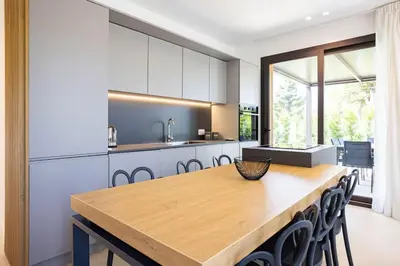 a kitchen with a wooden table and chairs at Luxury Jacuzzi Villa Atena in Palermo