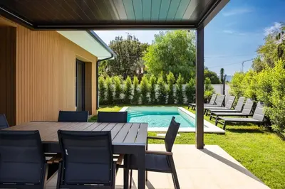a patio with a table and chairs and a swimming pool at Luxury Jacuzzi Villa Atena in Palermo