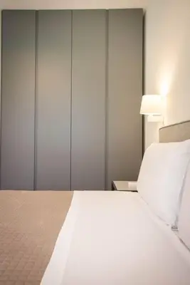 a bedroom with a large white bed and a lamp at Luxury Jacuzzi Villa Atena in Palermo