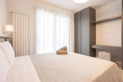 a bedroom with a white bed with a pillow on it at Luxury Jacuzzi Villa Nettuno in Palermo