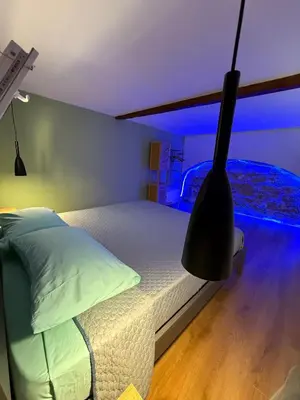 a bedroom with a bed with a blue light at L'angolo dei sogni in Palermo