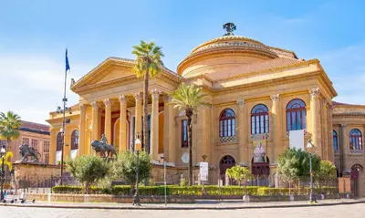a large building with palm trees in front of it at Goethe's Sicily trip - Palermo in Palermo