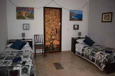 a bedroom with two beds and a wooden door at Goethe's Sicily trip - Palermo in Palermo