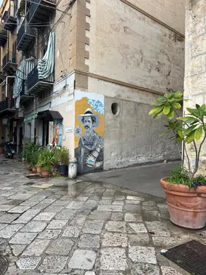 a mural of a man wearing a hat on a building at mastro casa vacanza in Palermo