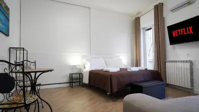 a bedroom with a bed and a table and a couch at Bieddu Suites - Palermo City Center in Palermo