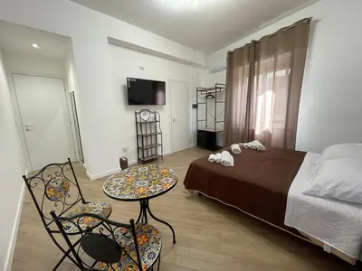 a bedroom with a bed and a table and chairs at Bieddu Suites - Palermo City Center in Palermo