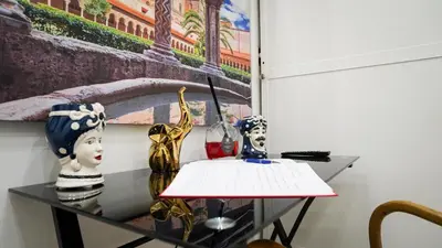 a glass table with vases and a painting on a wall at Bieddu Suites - Palermo City Center in Palermo