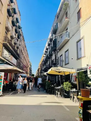 a group of people walking down a street with buildings at Bieddu Suites - Palermo City Center in Palermo