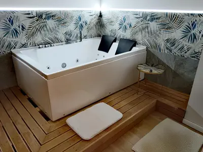 a white bath tub sitting on top of a wooden floor at Kalos suite in Palermo