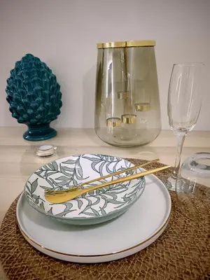 a table with a plate and two glasses and chopsticks at Kalos suite in Palermo