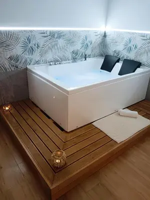 a white bath tub sitting on top of a wooden floor at Kalos suite in Palermo
