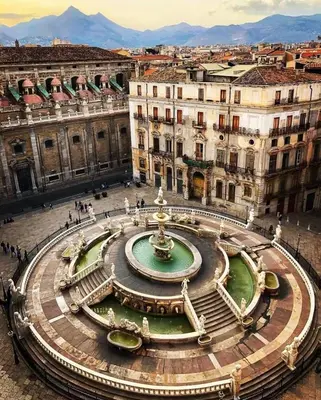 a fountain in the middle of a city with buildings at Kalos suite in Palermo