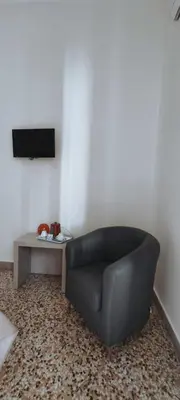a black leather couch sitting in a living room with a table at Il Quadrifoglio Room& Suite in Palermo