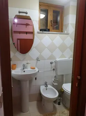 a bathroom with a sink and a toilet and a mirror at Fra centro & mare in Palermo