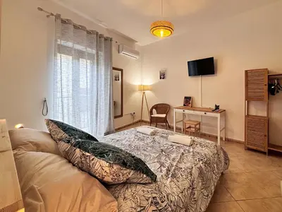 a bedroom with a bed and a desk and a television at Casa Cassarelli in Centro in Palermo
